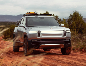 Picture of a silver-black Rivian truck on an unmetalled road