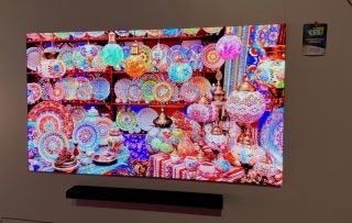 A Samsung 75 Micro LED TV mounted to a wall displaying a picture of crockery