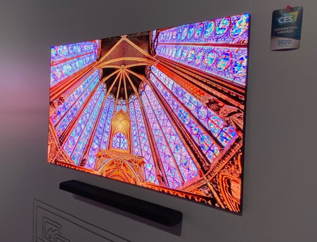 Side view of a Samsung 75 Micro LED TV mounted to a wall displaying a picture of round roof