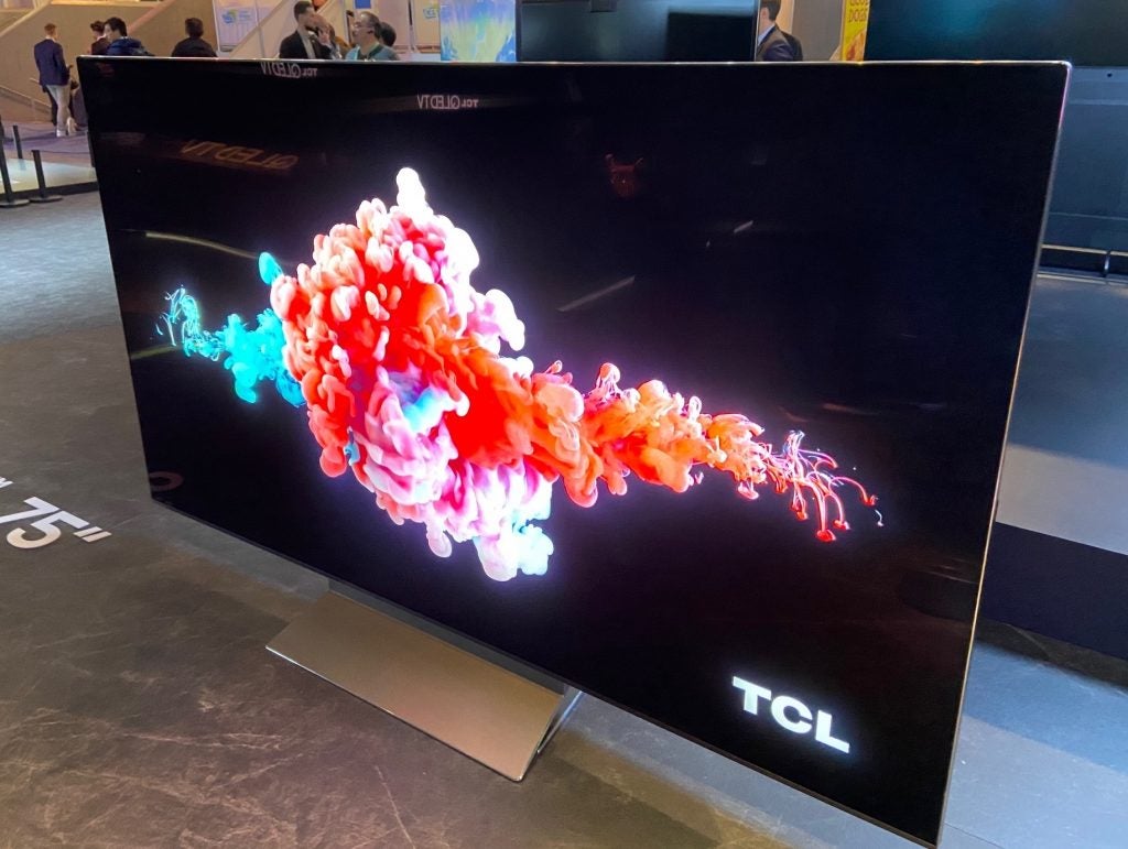 Side view of a silver TCL Vidrian 8K TV standing on a table in a store