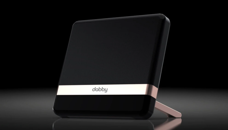 A black, white and gray Dabby streaming device standing on a dark background
