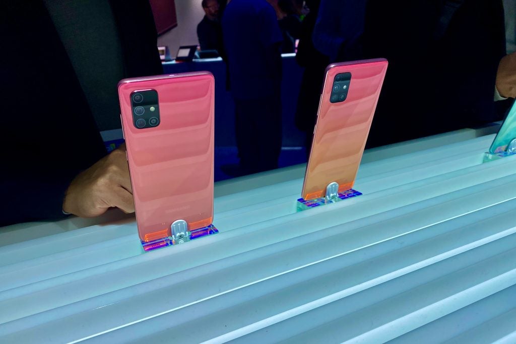 Back panel view of pink-orange Samsung Galaxy A71s standing on stand