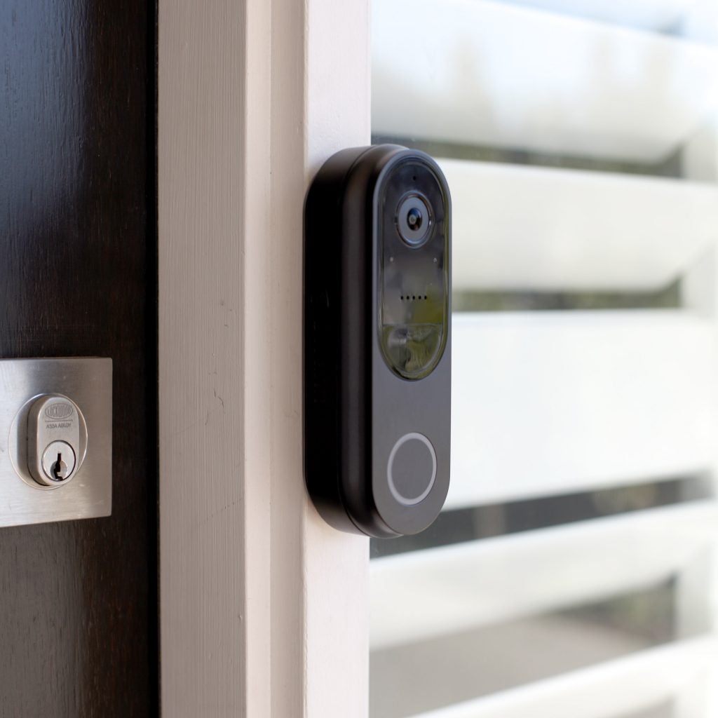 Close up image of a black Gen 3 doorbell fixed on side of a door