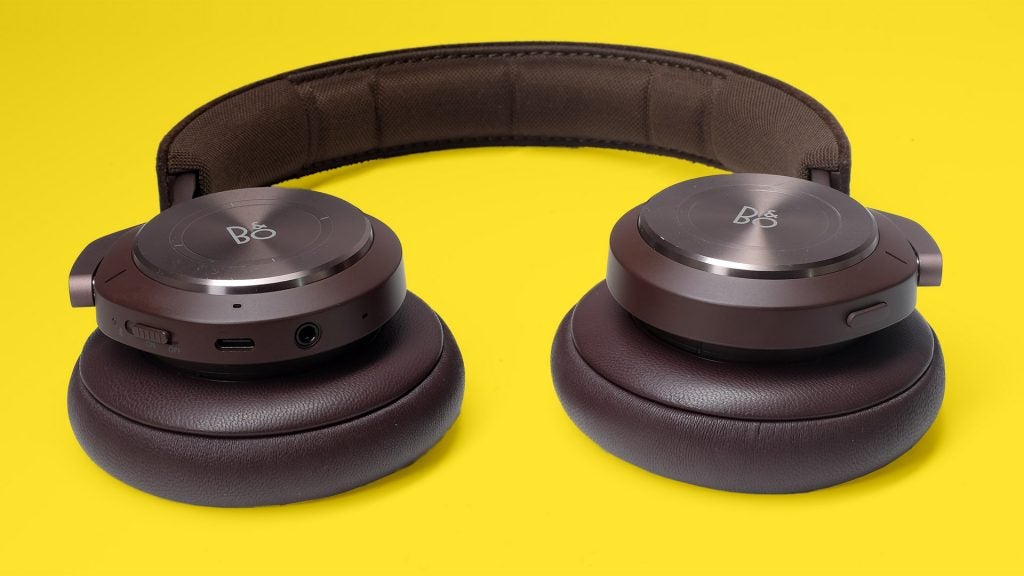 Beoplay H9 3rd GenClose up picture of black B&O headphone's earcups kept on a yellow background
