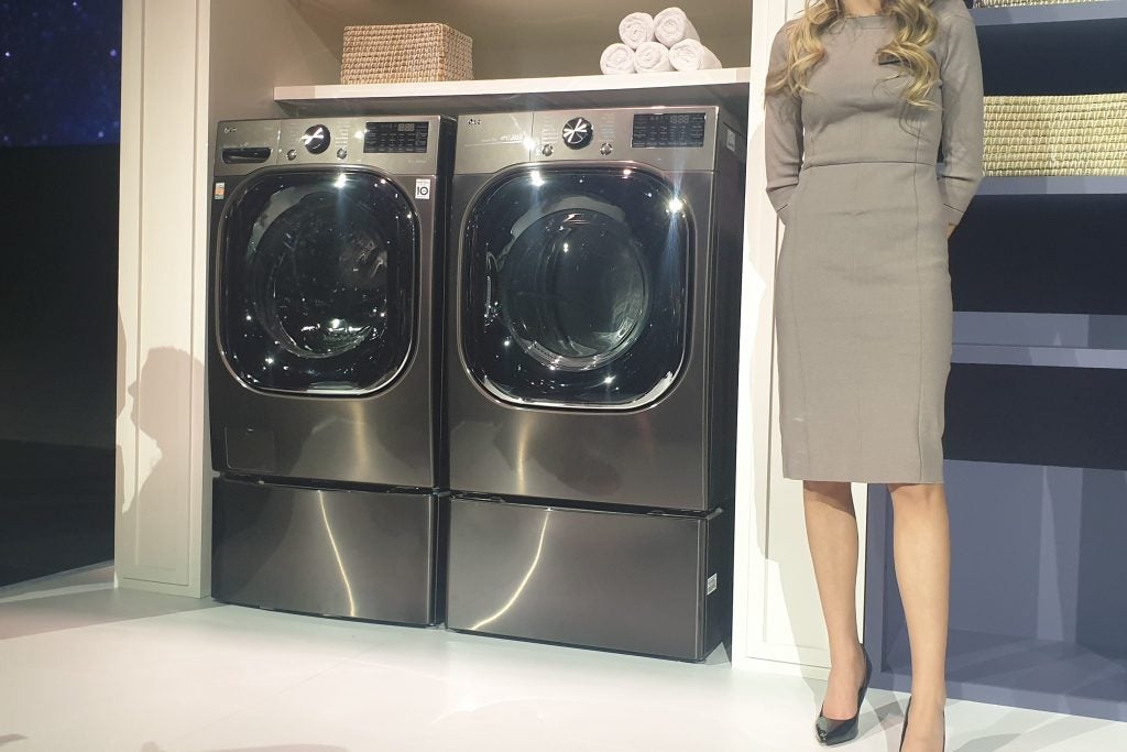 A picture of LG ThinQ Washer & Dryer with a woman standing beside