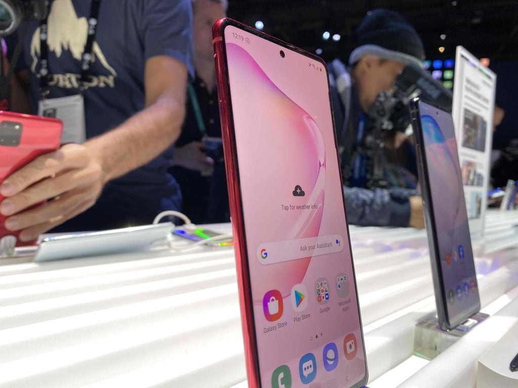 Side view of two Samsung Galaxy Note 10 Lite standing on a table displaying homescreen