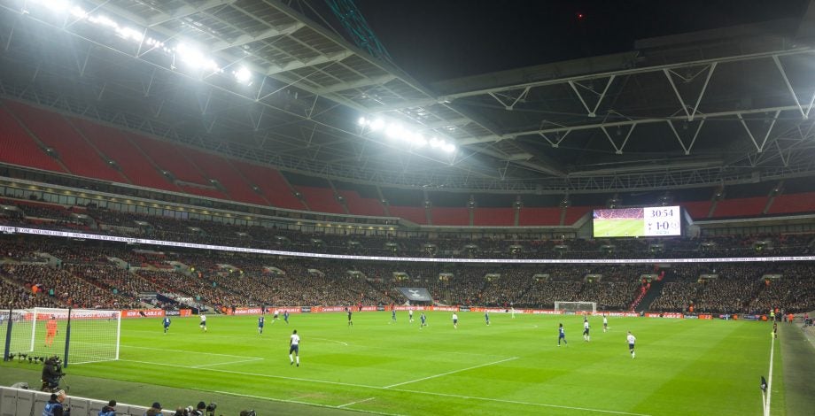 A picture of an ongoing soccer match in a stadium, taken from audience seat