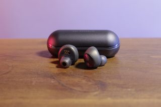 Picture of Amps Air Plus earbuds with it's case behind kept on a table