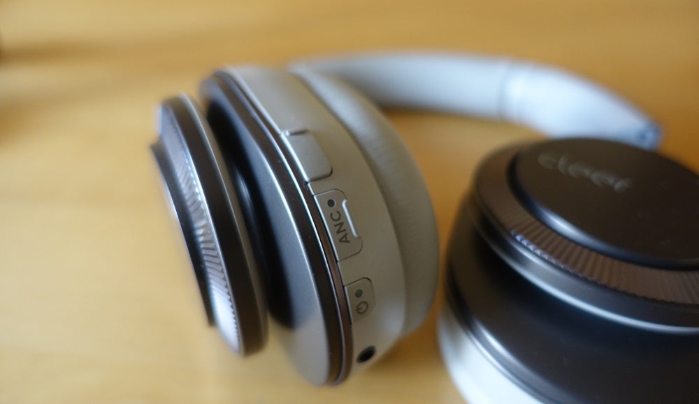 Close up image of blue-silver and black Cleer Flow II headphone's buttons on earcups