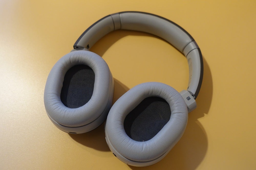 View from top of blue-silver Cleer Flow II headphones kept on a table, earcups inside view