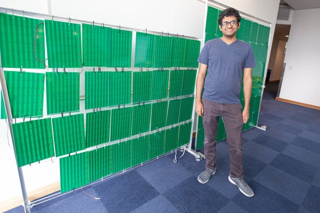 A picture of lead author Venkat Arun in front of the Rfocus prototype