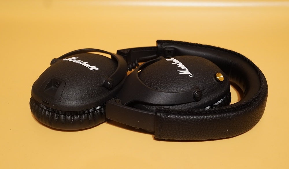Black Marshall monitor II ANC headphones kept on a yellow table with folded earcups