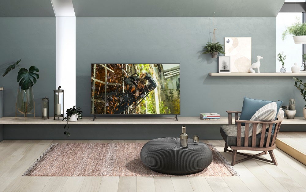 A black Panasonic HX900 TV standing on a table in a living room