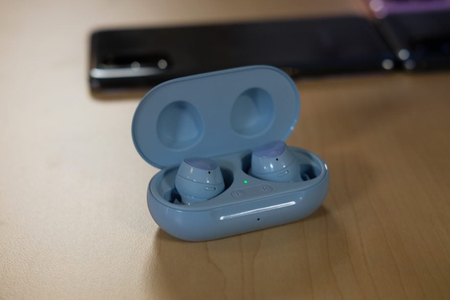 Blue Samsung Galaxy Buds Plus resting in it's case on a table