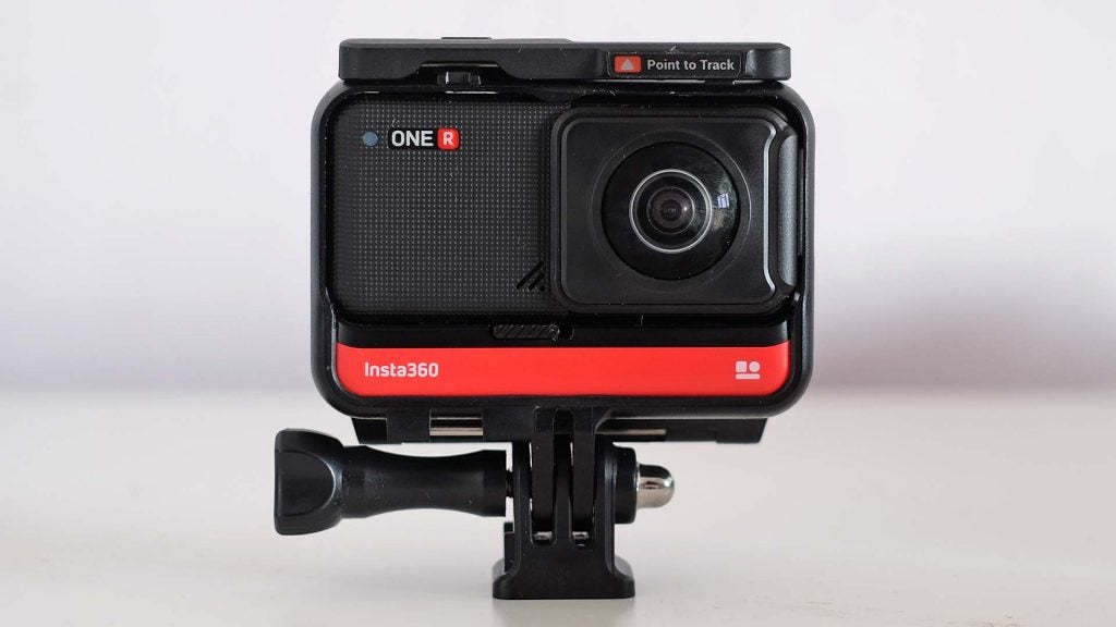 A black-red Insta 360 One R camera standing on white background