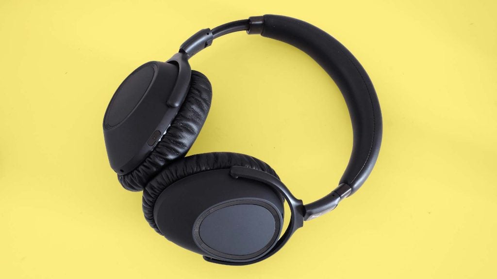 Side view from top of black headphones kept on a yellow background