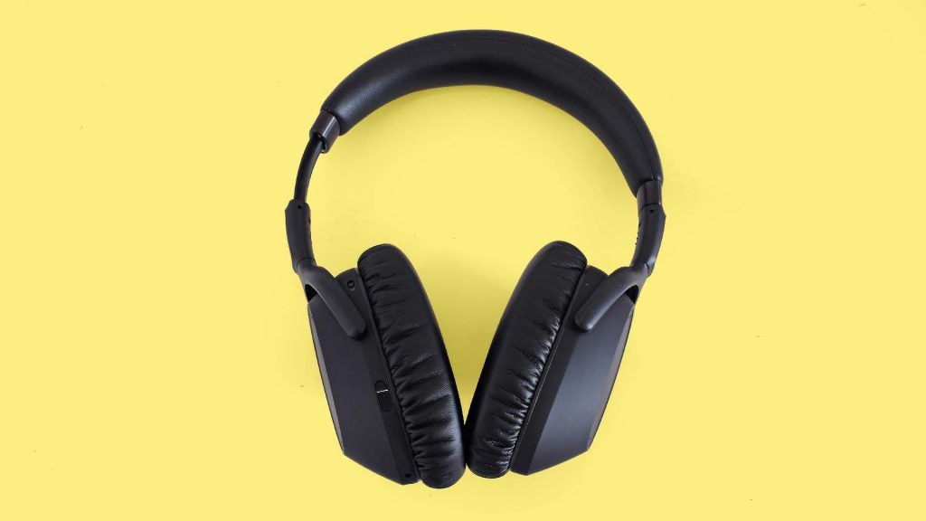 Side view from top of black headphones kept on a yellow background