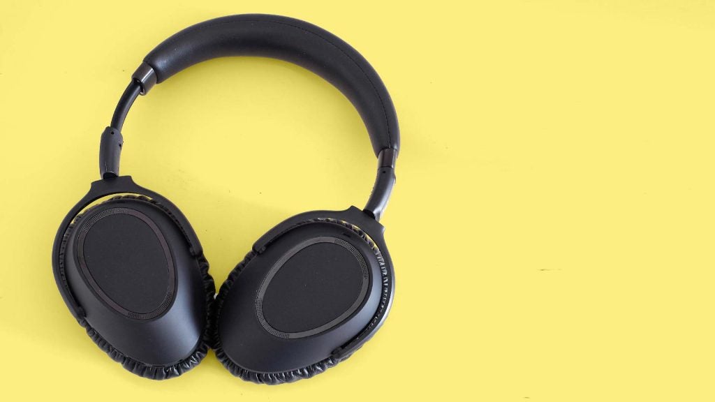 View from top of black headphones kept on a yellow background