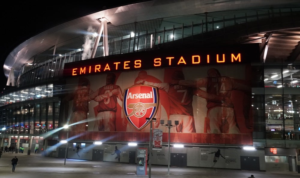 A picture of a stadium with a banner outside that says Emirates Stadium