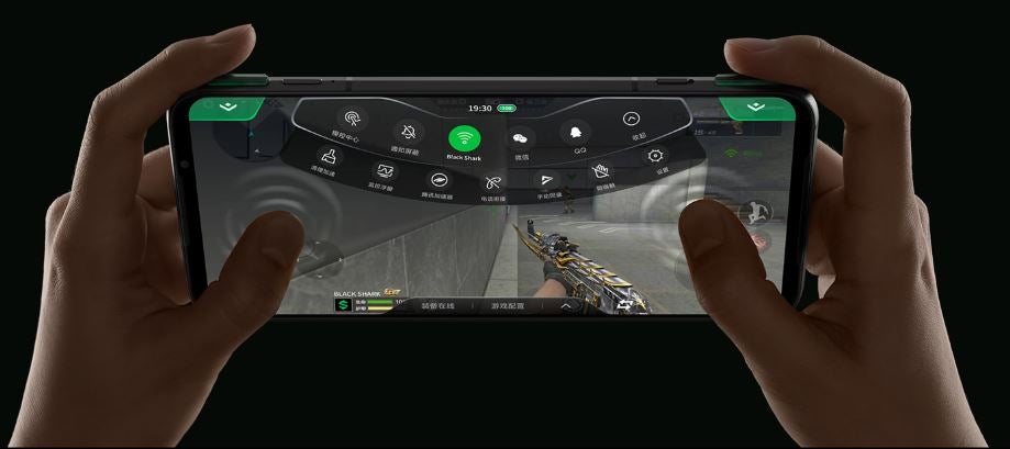 A Black Shark 3 Pro held in hand displaying a game being played on