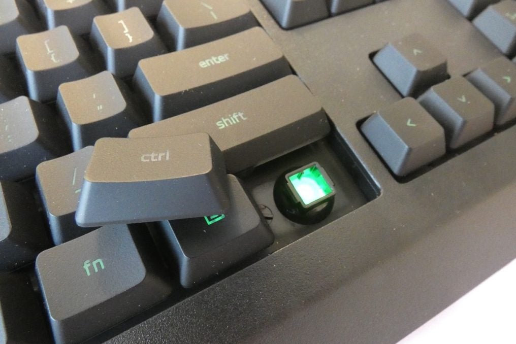 View from top of a black Cynosa Lite keyboard kept on a white backgroundClose up image of a removed ctrl key of a black Cynosa Lite keyboard with green light beneath it