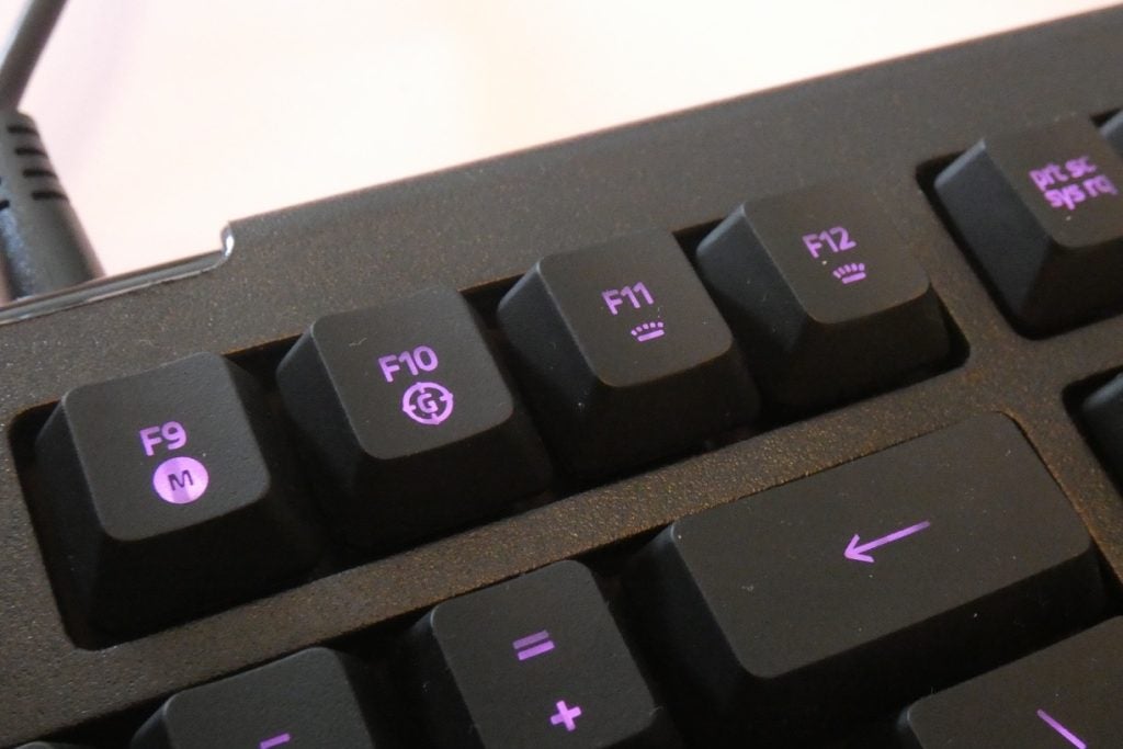 Close up image of F9-F12 keys section of a black Cynosa Lite keyboard with purple lights beneath the keys