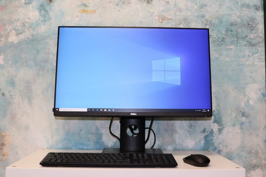 A black Dell Optiplex 7070 Ultra connected to monitor and other peripherals standing on a white table