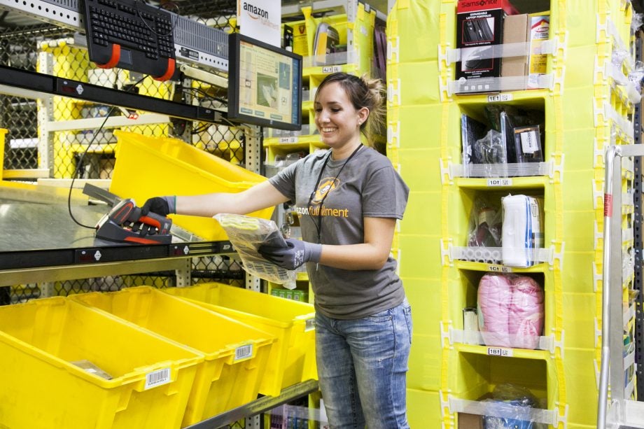 A woman wearing Amazon fullfilment t-shirt working in a warehouse