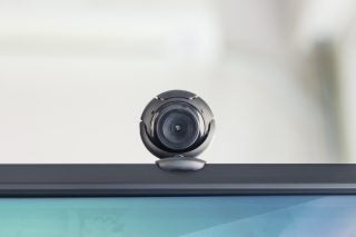 Close up picture of a silver webcam attached on top of a computer monitor