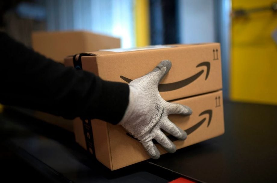 A picture from Germany retail distribution Amazon, cartoon boxes being picked up by hands in gloves