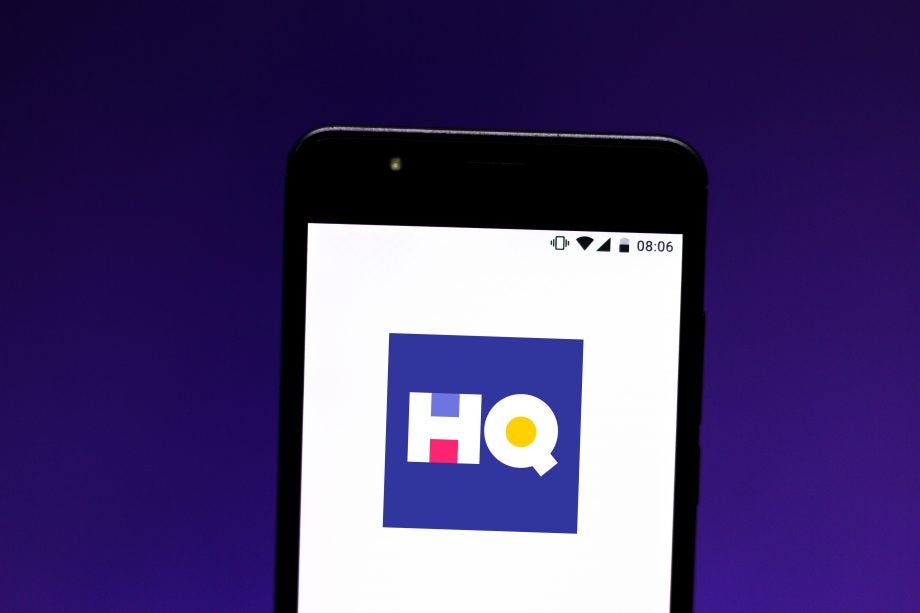 A black smartphone standing on blue background displaying HQ wallpaper