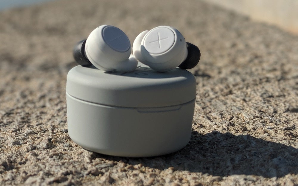 White Kygo E7/1000 earbuds resting on it's case 