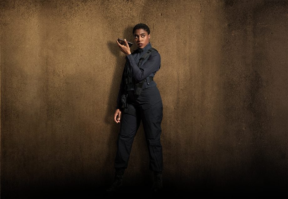 Lashana Lynch standing in blue outfit holding a Nokia 7.2 smartphone in hand