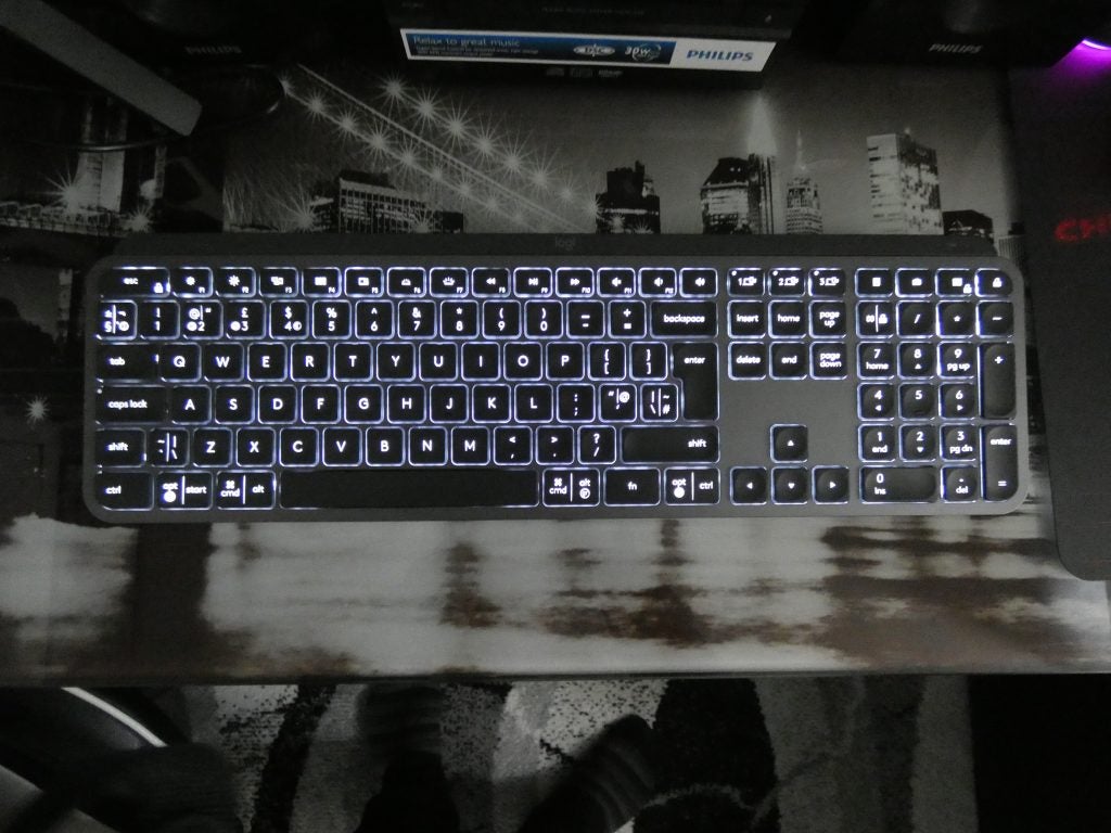 View from top of a black Logitech MX keyboard kept on a table with lights beneath the keys