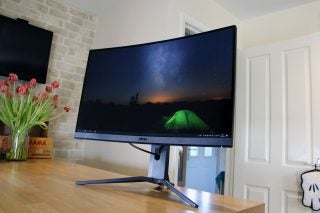 A gray-black MSI Optix MAG272CQR monitor standing on a table