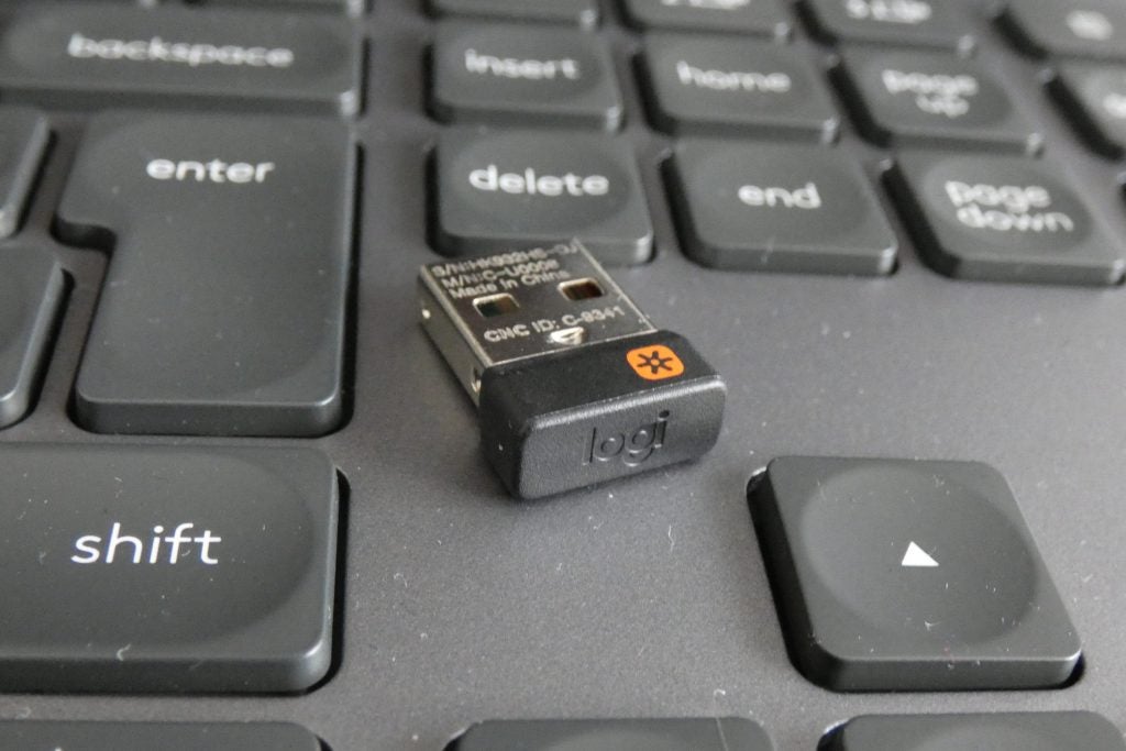 Logitech MX KeysA Logitech MX keyboard's USB adapter kept on a black keyboard