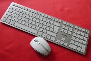 White DW9000 keyboard and mouse placed on a red background