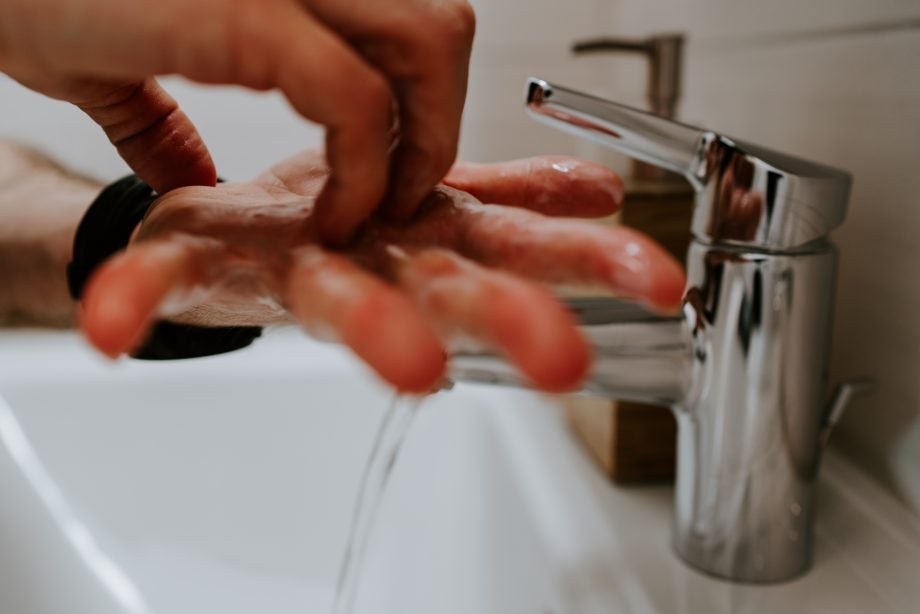 Picture of a person's hands being washed under tap