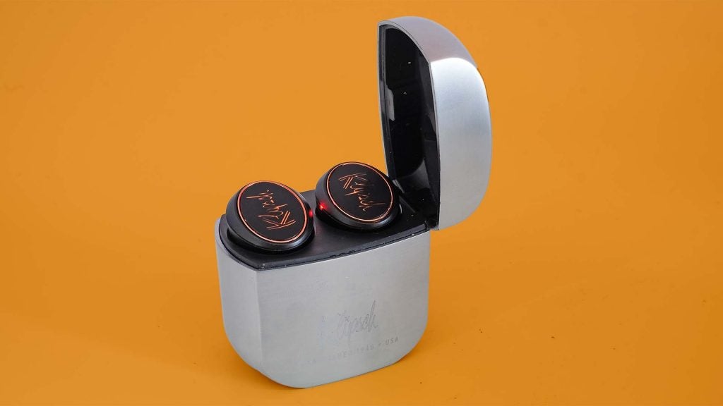 Black Klipsch earbuds resting in its case standing on a table
