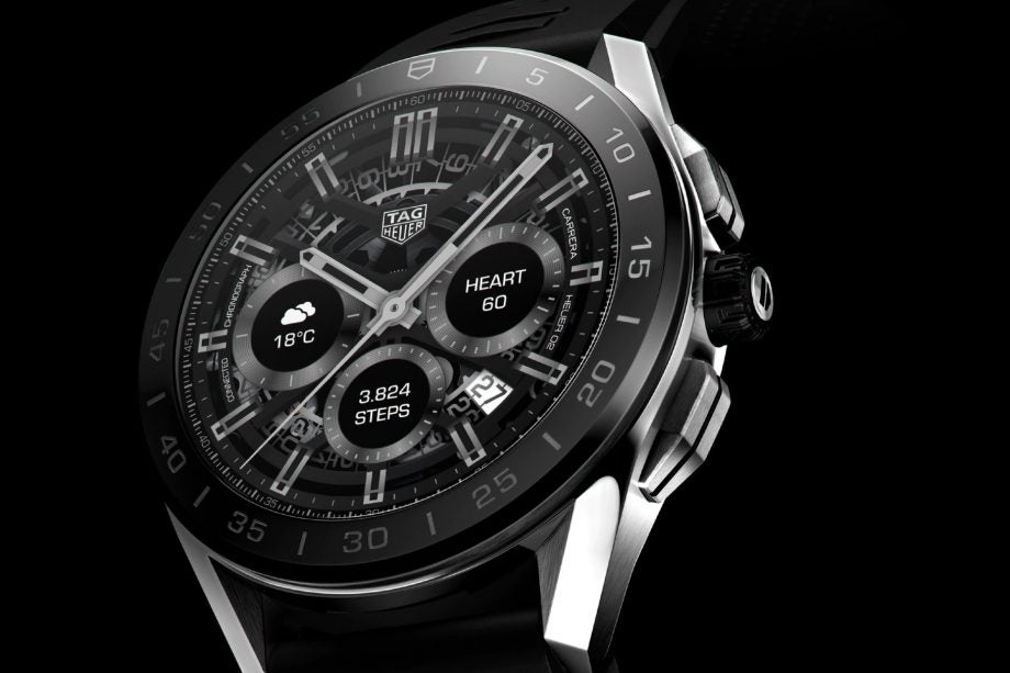 A silver-black Tag Heuer Connected watch standing on black background