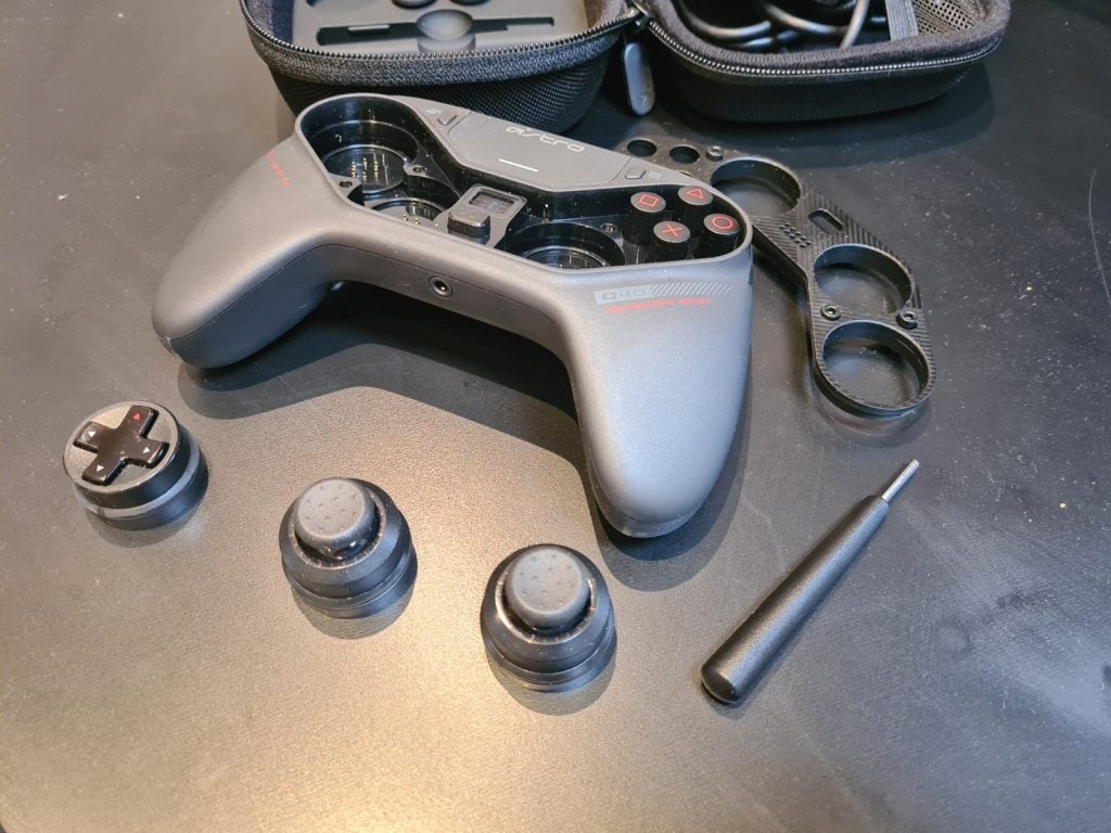 A black Astro C40 gaming controller disassembled with buttons and frames kept around