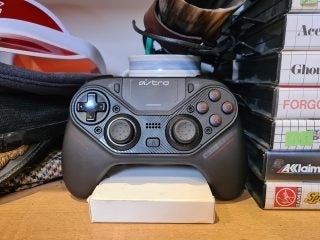 A black Astro gaming controller standing on a wooden table