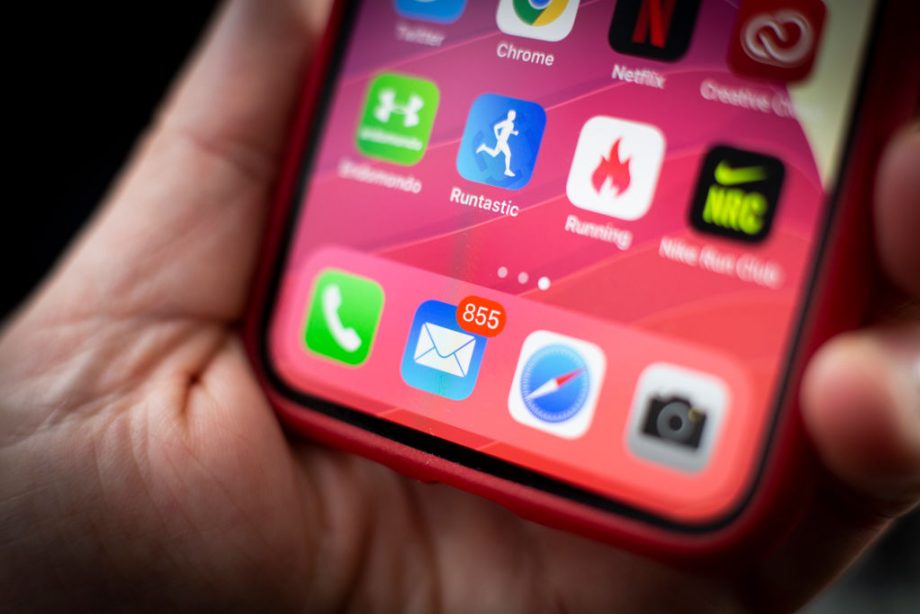 Close up image of iPhone's mail app on a red iPhone held in hand