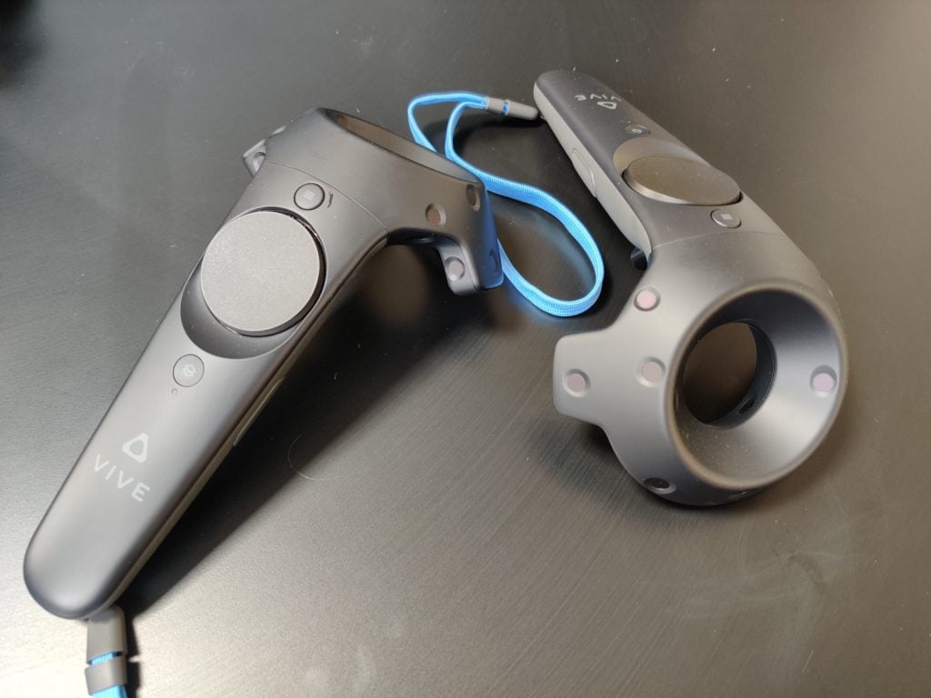 Picture of black Vive Cosmos Elite VR controllers kept on a black table