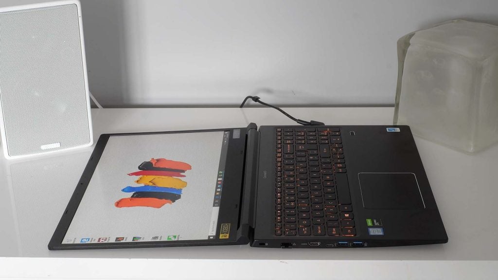 A black ConceptD laptop opened flat kept on a white table