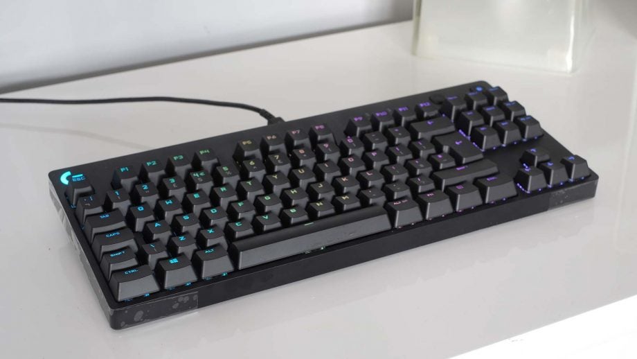 A black Logitech G Pro keyboard kept on a white table