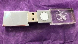 A silver and transparent glass 5GBioShield USB stick