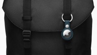 An Apple Airtag attached to black backpack