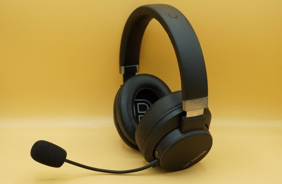 Side view of black Creative SXFI theater headphones standing on a yellow background