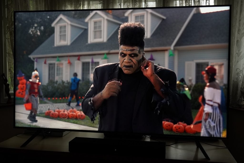 Samsung QLED playing Miracle on Disney Plus, a man named Herb Brook stand in black outfit and halloween theme behind him